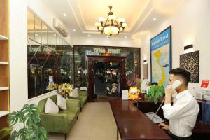 a man talking on a cell phone in a store at Golden Lotus Hotel & Spa in Hanoi