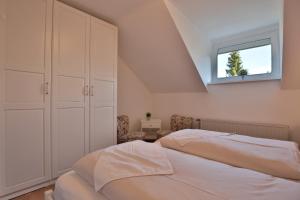 een slaapkamer op zolder met 2 bedden en een raam bij Appartemenhaus Linda-Lu Appartementhaus Linda-Lu Appartement 8 in Scharbeutz