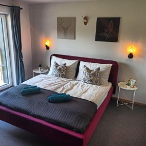 een slaapkamer met een groot bed met kussens erop bij DAS TONIS - IHR Bett im Herzen des Salzkammergutes in Bad Goisern