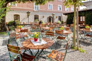 een groep tafels en stoelen voor een gebouw bij Hotel Pfaubräu in Trostberg an der Alz