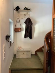 a set of stairs with a coat hanging on the wall at Haus Fremerey in Krün