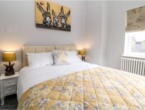 a bedroom with a large bed and two lamps at Babbling Brook Cottage in Stony Middleton