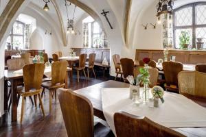 un restaurante con mesas, sillas y ventanas en Hotel Pfaubräu, en Trostberg an der Alz