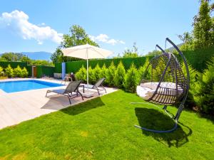 - une balançoire dans l'herbe à côté d'une piscine dans l'établissement Villa Limon Kayakoy - Private Swimming Pool, à Belen