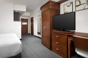 a hotel room with a flat screen tv and a bed at Courtyard By Marriott Little Rock North in North Little Rock