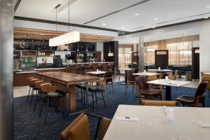 a restaurant with tables and chairs and a bar at Courtyard By Marriott Little Rock North in North Little Rock