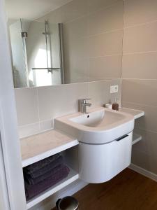 a white bathroom with a sink and a mirror at Julie's Boutique Guesthouse Ghent in Ghent