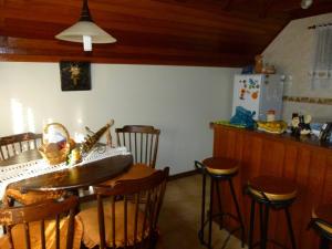 cocina con mesa, sillas y nevera en Hospedaria Bela Vista do Vale, en Lumiar