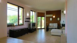 a living room with a couch and a tv in it at Вила Матилда - Villa Matilda in Bŭlgarevo