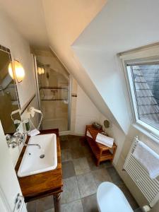 a attic bathroom with a sink and a window at Hotel zur Römerbrücke in Neuwied