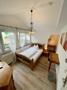 ein Schlafzimmer mit einem großen Bett und einem Kronleuchter in der Unterkunft Hotel zur Römerbrücke in Neuwied