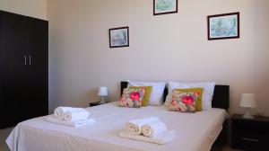 a bedroom with a white bed with towels on it at Вила Матилда - Villa Matilda in Bŭlgarevo +58 photos