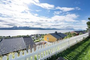 a white fence with a view of the water at Well-Equipped Apartment with Stunning Views in Bodø