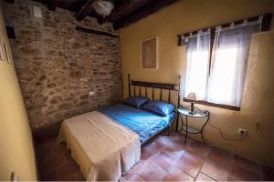 a bedroom with a bed in a room with a window at Casa Rural EL TRULL in Canet lo Roig