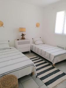 2 łóżka w białym pokoju ze stołem i spódnicą w obiekcie Le Farniente, maison 2pas piscine, 5mn à pied mer w mieście Saint-Aygulf +15 zdjęć