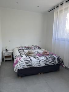 łóżko stojące w pokoju z oknem w obiekcie N1 Maison T2 climatisé w Ajaccio