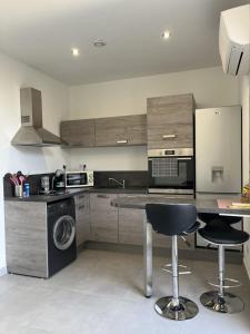 kuchnia z blatem i dwoma krzesłami barowymi w obiekcie N1 Maison T2 climatisé w Ajaccio