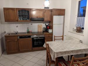 a small kitchen with wooden cabinets and a table with a tableablish at Salzhaff 4 You in Teßmannsdorf