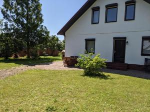 uma casa branca com um banco no quintal em Salzhaff 4 You em Teßmannsdorf