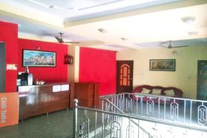 - un salon avec des murs rouges et un escalier dans l'établissement Goroomgo Kashi Inn Varanasi Near Railway Station, à Varanasi