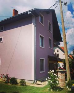 a purple house with a large garage at Smestaj Vlasina in Surdulica