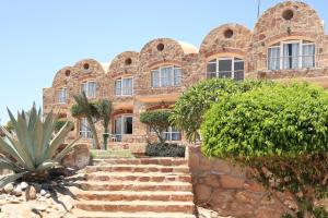 a stone building with stairs in front of it at Pensee Royal Garden Beach Resort in Quseir