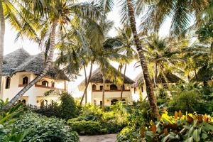 a house with palm trees in front of it at Essque Zalu Zanzibar in Nungwi