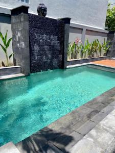 a swimming pool in front of a house at Villa Ayu Legian in Legian
