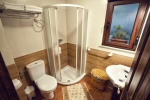 ein Badezimmer mit Dusche, Toilette und Waschbecken in der Unterkunft Apartamentos el Caserón in Soto de Cangas + 42 Fotos