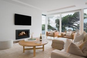 sala de estar con sofá y chimenea en The Cove Beach Front Luxury House, en Port Fairy