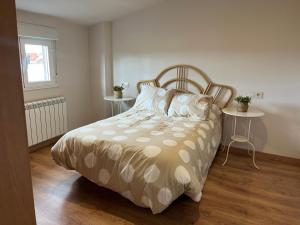 a bedroom with a bed with two tables and a window at Casa Manuela in Castro Caldelas