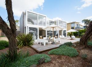 Casa con terraza de madera con sombrilla en The Cove Beach Front Luxury House, en Port Fairy