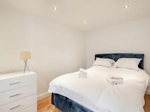a bedroom with a white bed and a white dresser at Charming 1 Bedroom Cottage in Doncaster