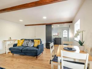 a living room with a blue couch and a table at Charming 1 Bedroom Cottage in Doncaster