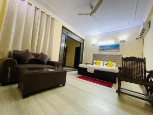a living room with a couch and a bed at Hotel Sunrise,Noida in Noida