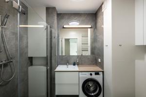 een badkamer met een wasmachine en een wastafel bij ShortStayPoland Pohulanka (B86) in Warschau