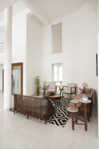 ein Wohnzimmer mit Tischen, Stühlen und einem Teppich in der Unterkunft ama Stays & Trails White House, Lonavala in Lonavla