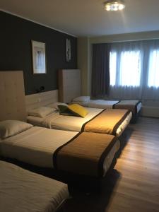 une chambre d'hôtel avec 4 lits dans l'établissement Albert Hotel, à Bruxelles