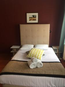 1 cama con 2 toallas y 2 almohadas en Albert Hotel, en Bruselas
