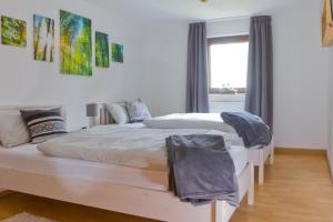 two white beds in a room with a window at Ferienhaus Ziegelhof in Poppenhausen