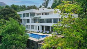 eine Luftaufnahme eines Hauses mit Swimmingpool in der Unterkunft ama Stays & Trails White House, Lonavala in Lonavla