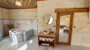 een badkamer met een bad en een grote spiegel bij Premium Cappadocia House in Goreme