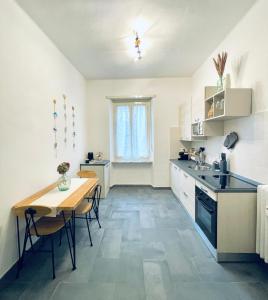 een keuken met een tafel en een kleine tafel en een tafel en stoelen bij Casa Milù in Turijn
