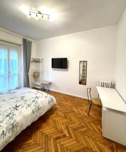 een slaapkamer met een bed, een bureau en een televisie bij Casa Milù in Turijn