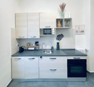 a kitchen with white cabinets and a sink at Casa Milù in Turin