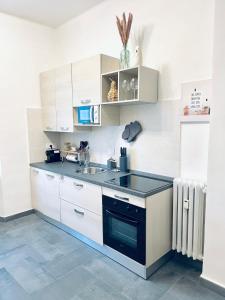 a kitchen with white cabinets and a sink at Casa Milù in Turin