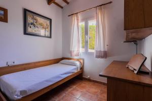 um pequeno quarto com uma cama e uma janela em Villa S'illot 105 By MENORCARENTALS em Son Bou