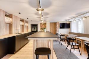 a kitchen with a bar with chairs and tables at Münsterhus by A-Appartments in Schruns