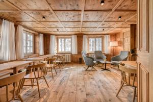 Pokój z drewnianą podłogą, stołami i krzesłami w obiekcie Münsterhus by A-Appartments w mieście Schruns
