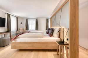 a bedroom with a large bed with a wooden headboard at Münsterhus by A-Appartments in Schruns